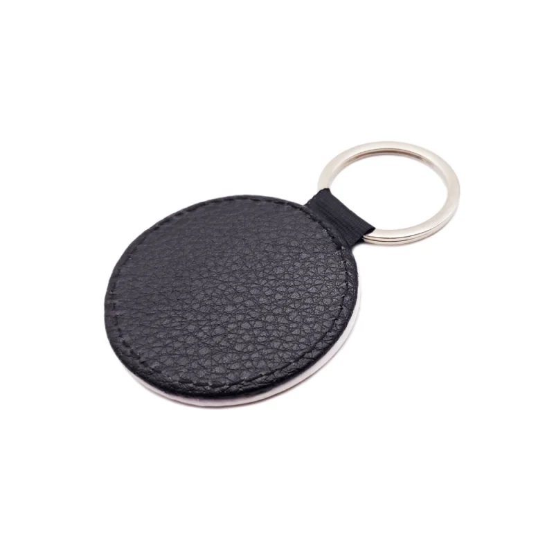 Back view of a personalized round-shaped PU leather keychain with black textured litchi grain finish