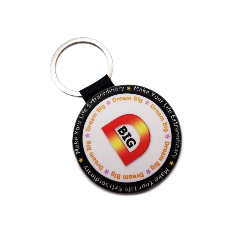 Close-up front view of a personalized round-shaped PU leather keychain highlighting the custom 'Dream Big' text design