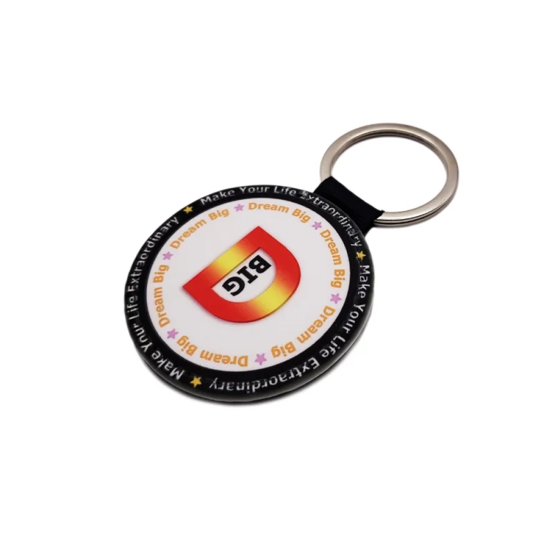 Slightly angled front view of a round-shaped PU leather keychain showcasing the custom design with 'Dream Big' text
